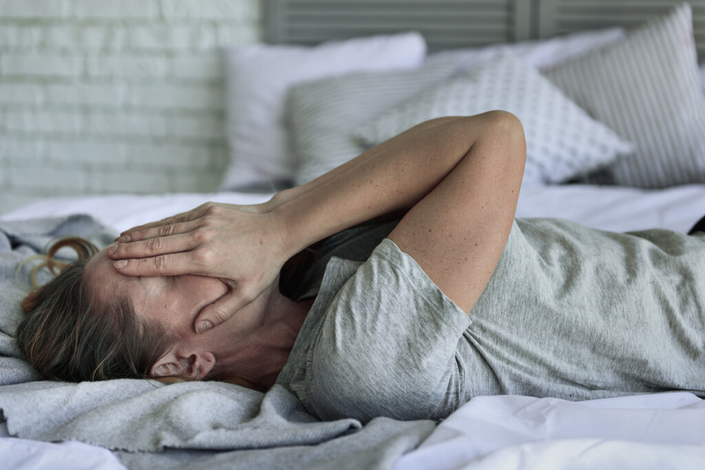 Mujer con ansiedad en la cama sintiendo emociones intensas