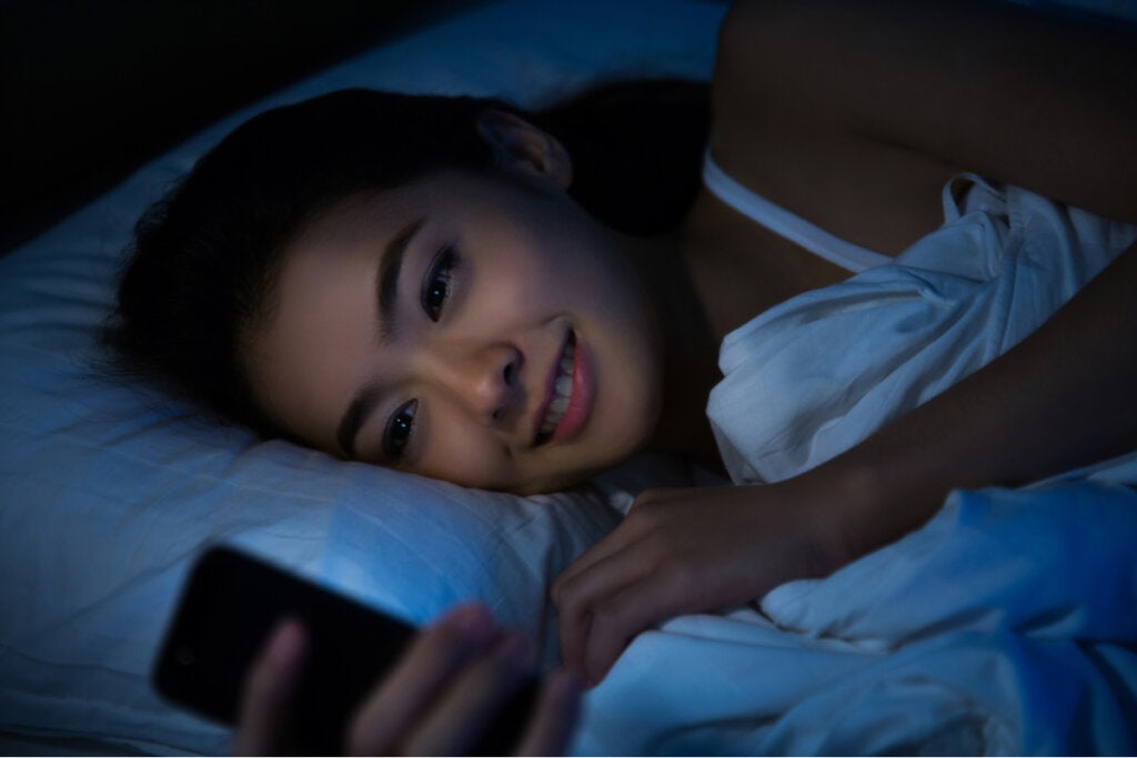 Mujer en la cama con el móvil