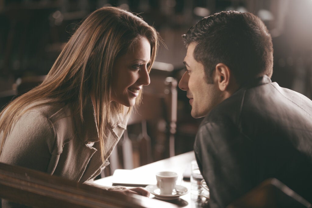 Mujer hablando con un hombre en cafetería haciendo uso de la Comunicación activo-constructiva