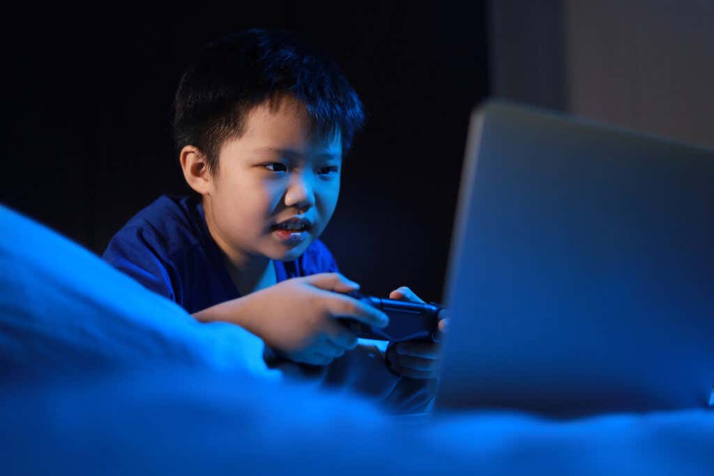 Asiatisk pojke som spelar videospel