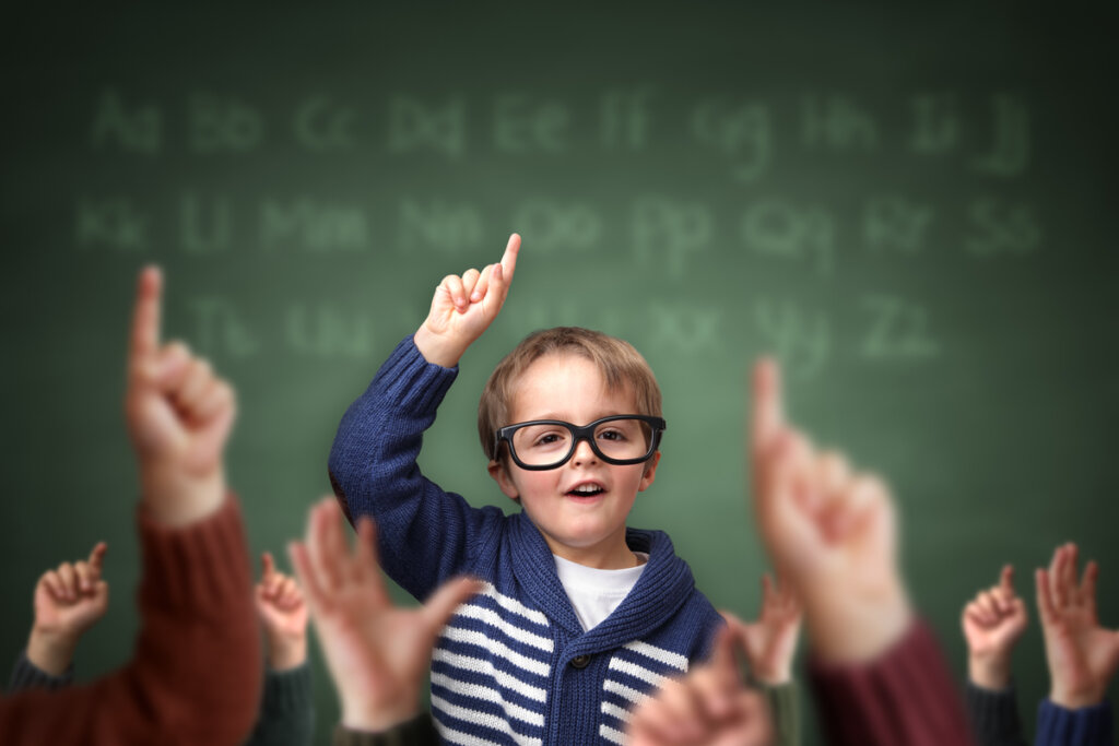Niño levantando la mano entre sus compañeros de clase intentando aprender a sintetizar