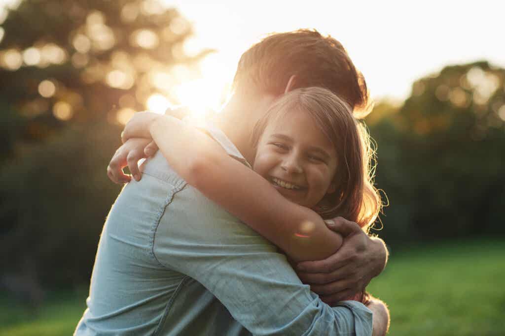 Vater, der seine Tochter umarmt, praktiziert positive Erziehung