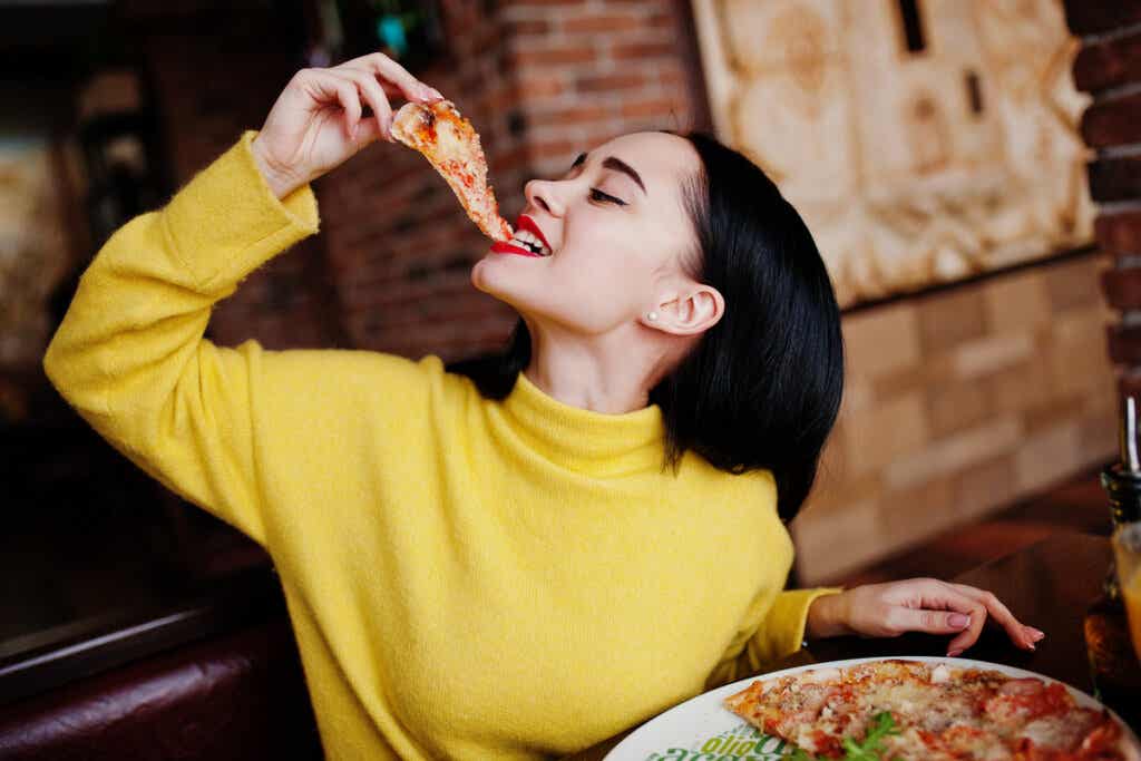 Donna che mangia pizza che simboleggia gli influencer nel cibo.
