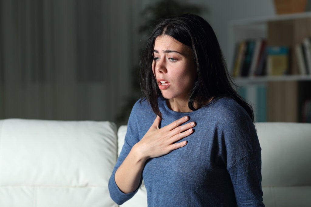 Mujer con dolor en el pecho pensando en Ir a urgencias por ansiedad