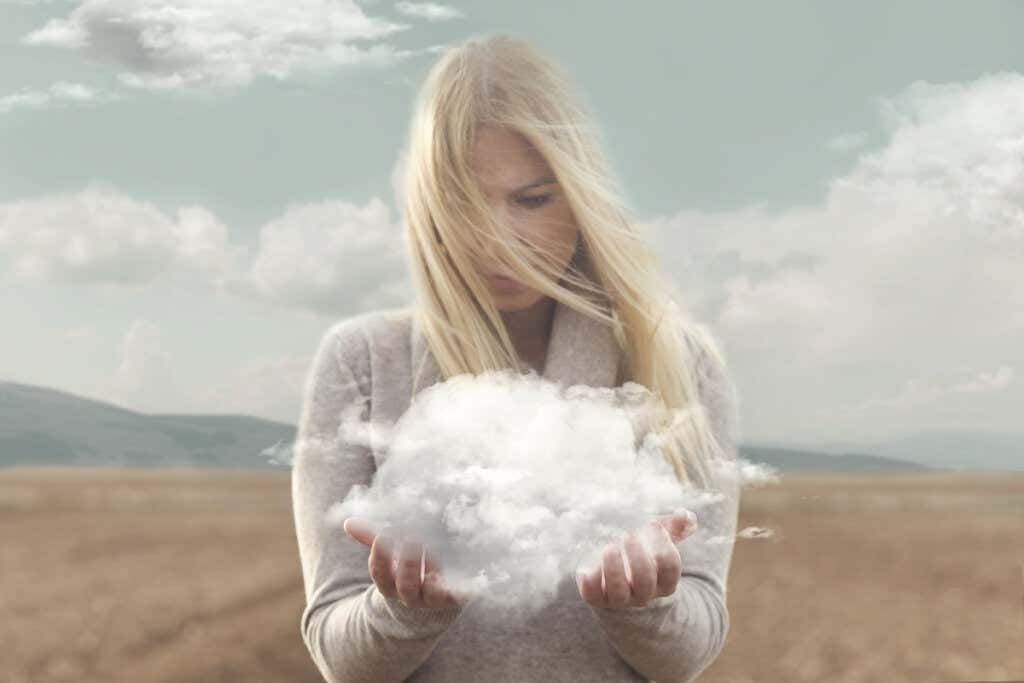 Mulher segurando uma nuvem com as mãos