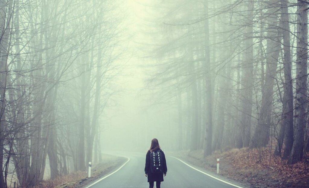 Fille devant une route pensant à surmonter une crise existentielle