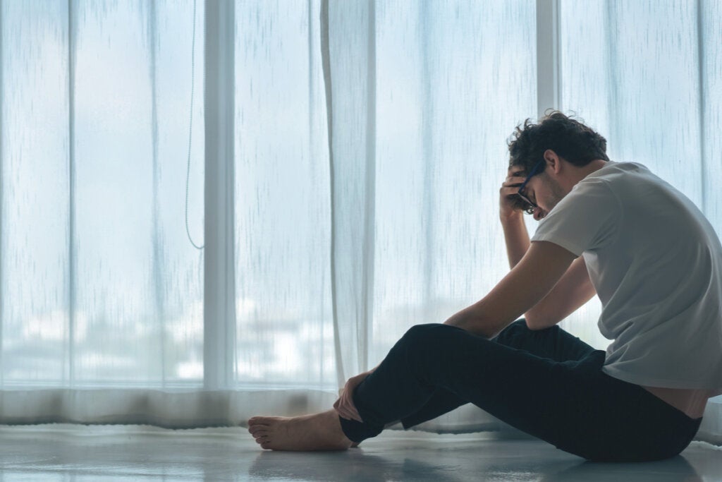 Gråtende mann som sitter på gulvet og tenker på emosjonell intelligens for å håndtere stress