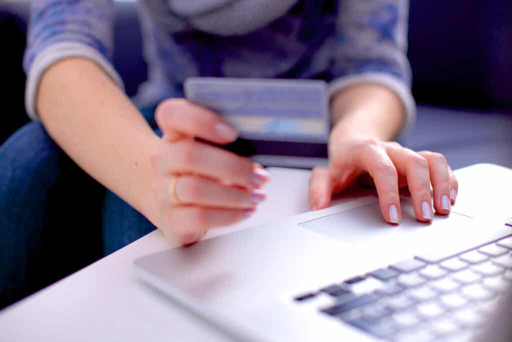 Frau zahlt mit Kreditkarte, da ein Produkt ihre Kundenbedürfnisse angesprochen hat