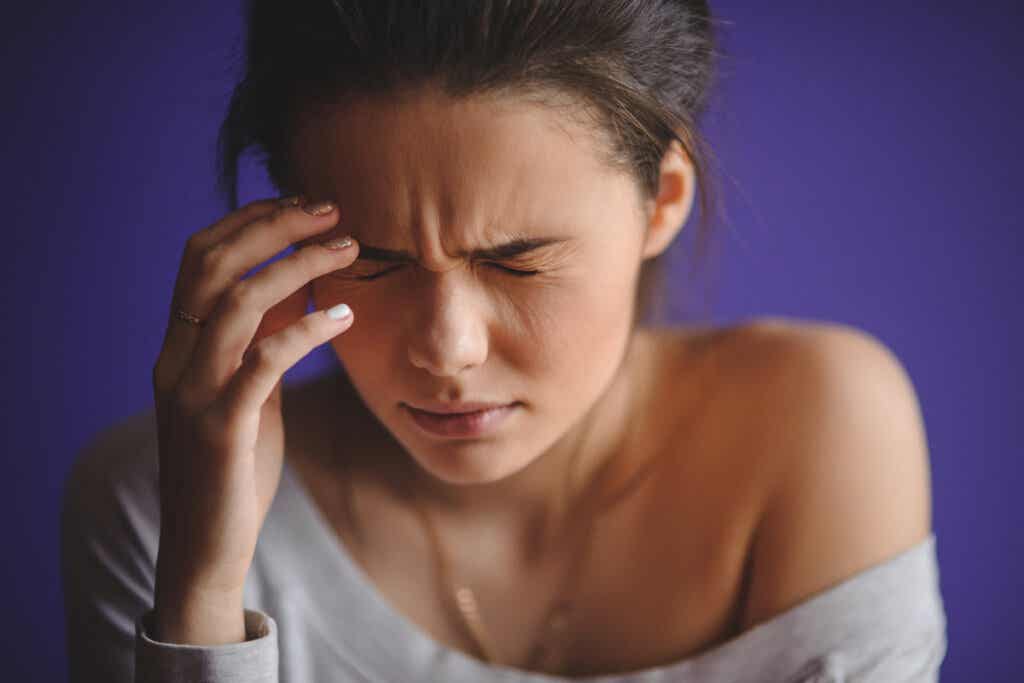 Kvinna som lider av menstruell migrän