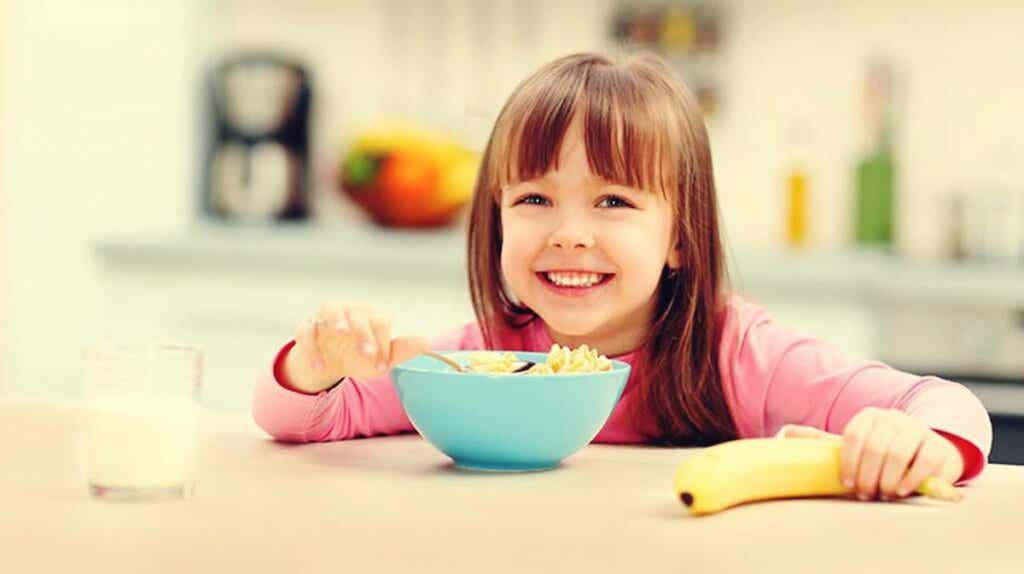 niña con bol cereales simbolizando la importancia del desayuno en el rendimiento escolar