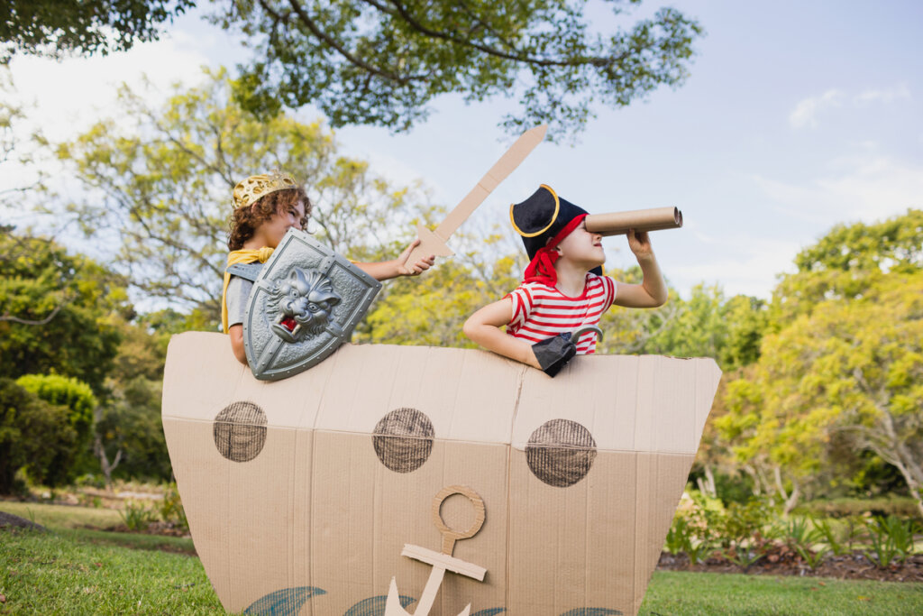 Niños disfrazados de piratas en un barco de cartón