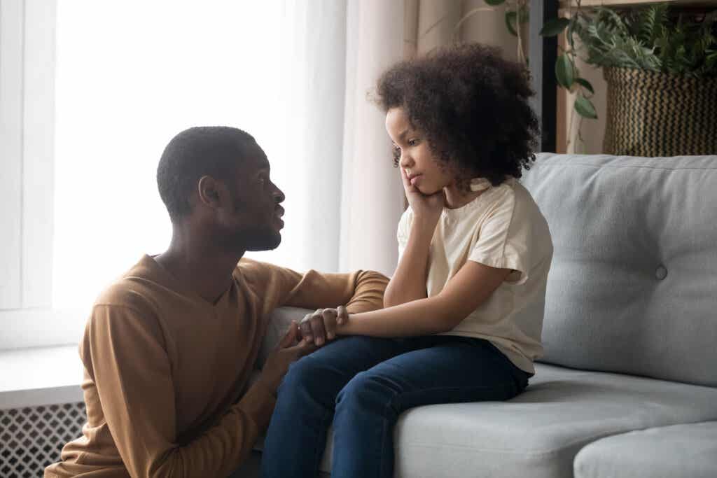 Padre hablando con su hija preadolescente para simbolizar cómo proteger a nuestros hijos contra la desesperanza