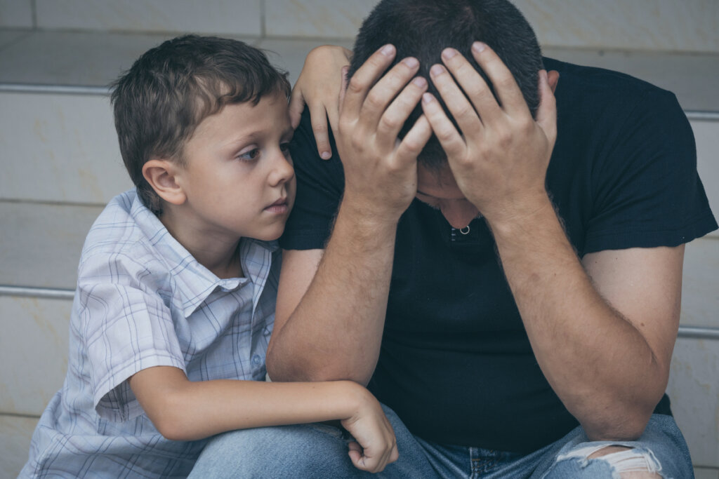 Padre triste con il suo giovane figlio che soffre di uno dei sottotipi di depressione maggiore