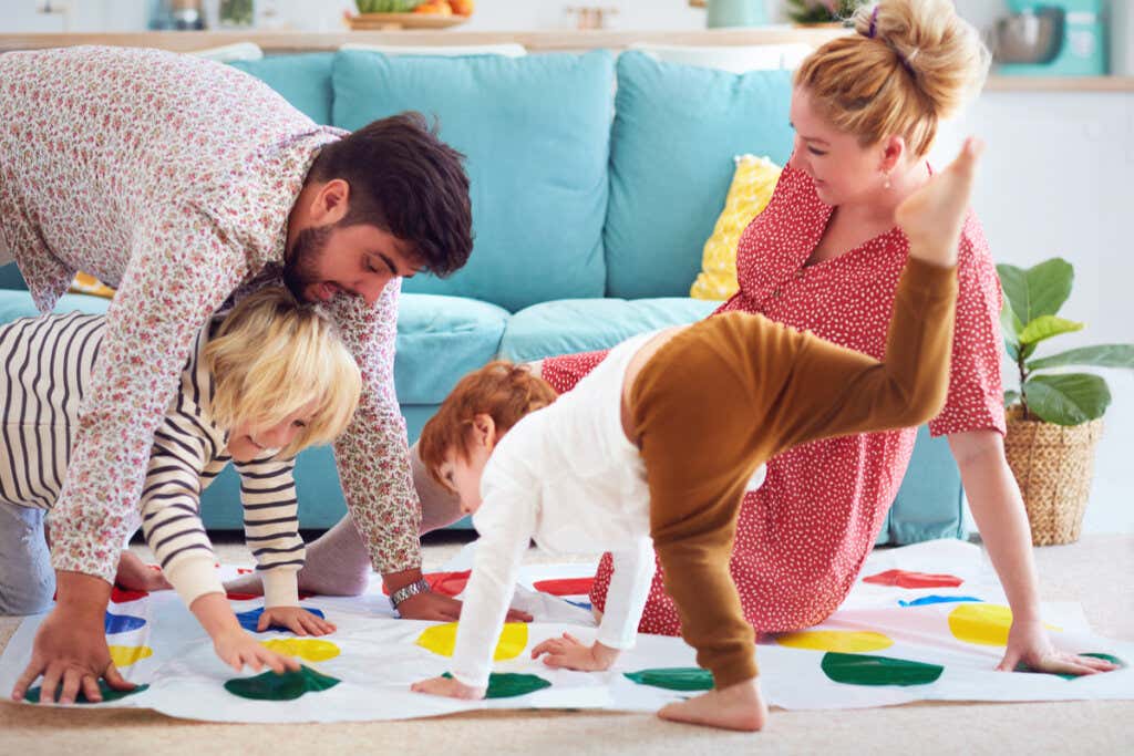 Padres jugando con sus hijos en el salón diferenciándose de las Familias hiperconectadas