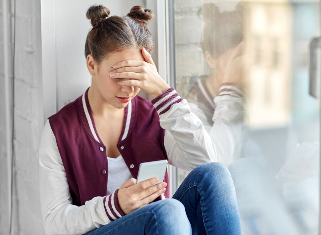 fille regardant un mobile représentant ce que les adolescents ont besoin de comprendre pour les adultes