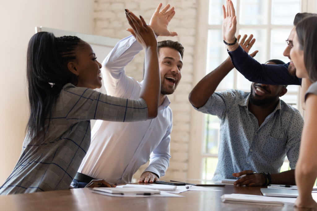 Travail d'équipe avec des high-fives heureux d'avoir appliqué un leadership résilient