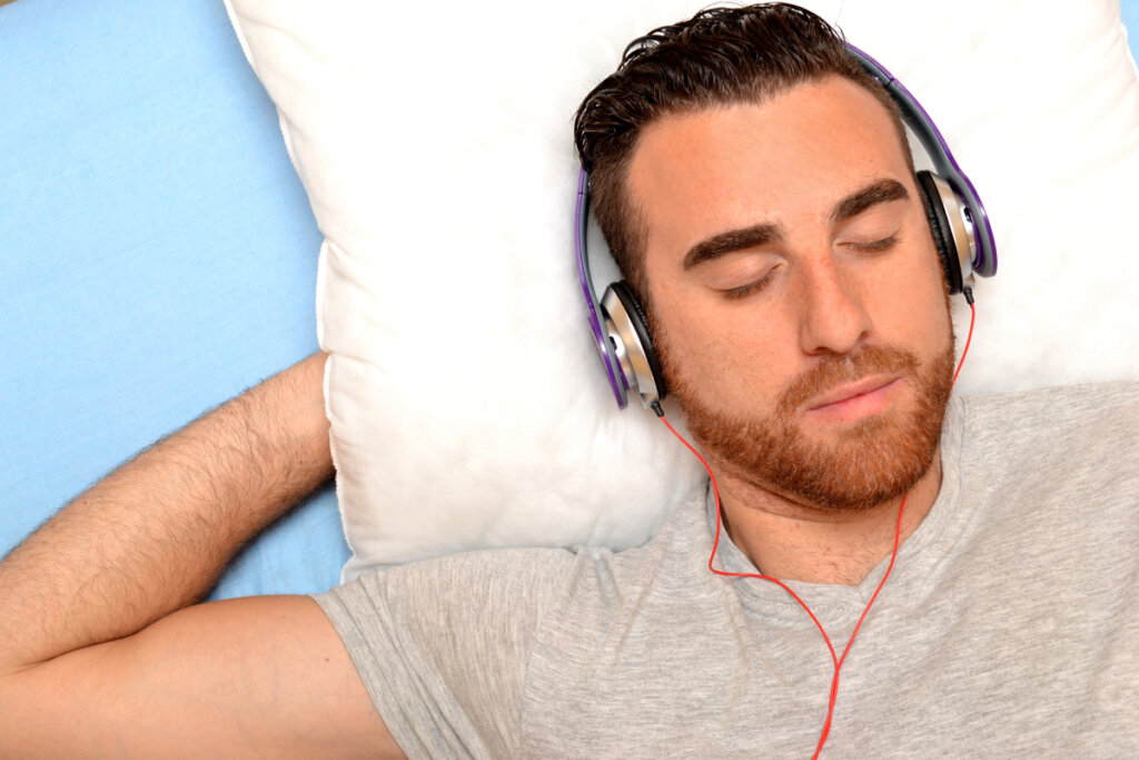 Hombre escuchando música en la cama