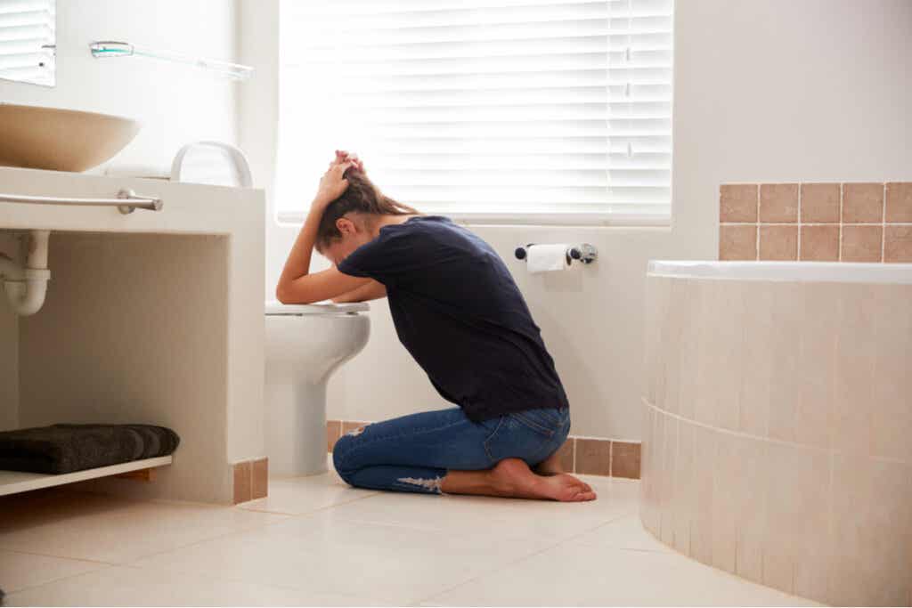 Mujer en el baño después de vomitar