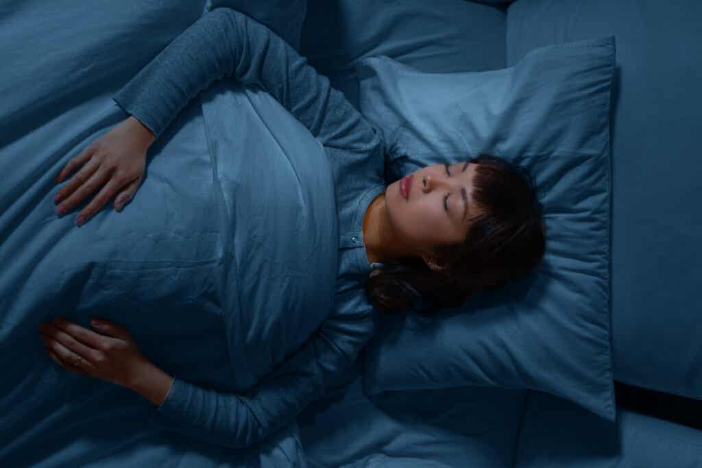 Kvinne som sover i blå laken, som viser hvordan farger påvirker søvnen din.