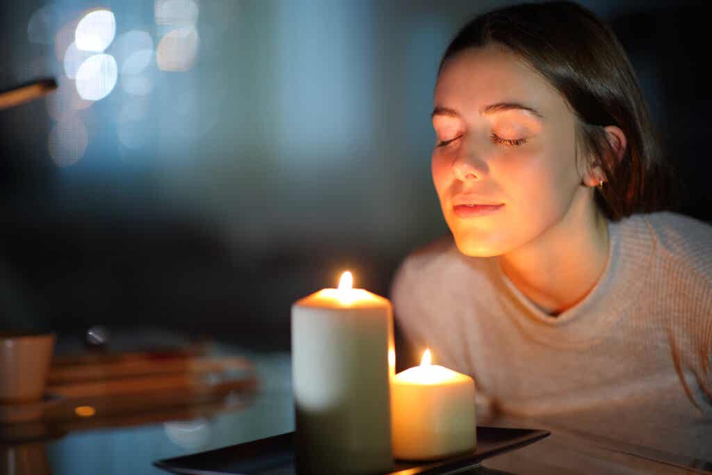 Mujer con dos velas haciendo un ritual para soltar el pasado