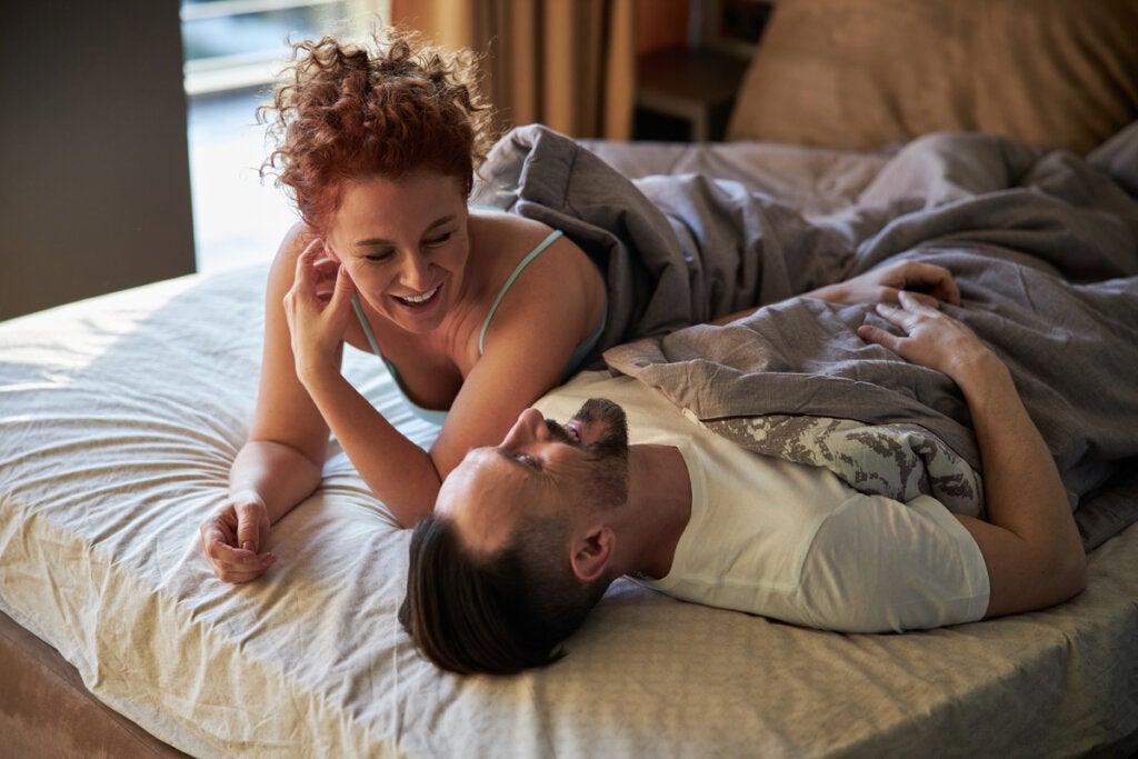 Couple talking in their bed, showing that they're having less sex.