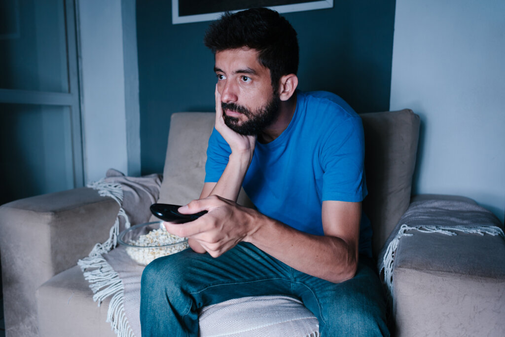Hombre desganado viendo la televisión