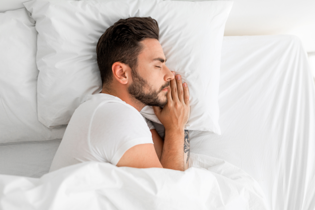 Homme endormi avec la main sous l'oreiller