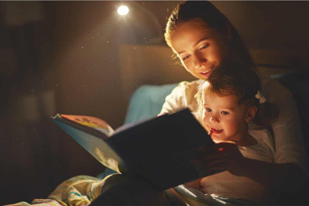 Matka czyta córce bajkę na dobranoc w nocy