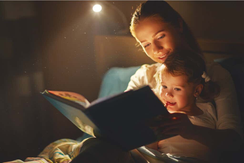 Madre leyendo un cuento a su hija por la noche