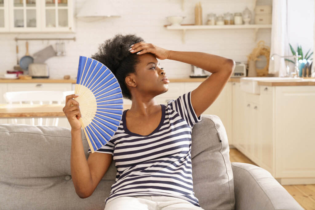 Mujer con calor abanicándose