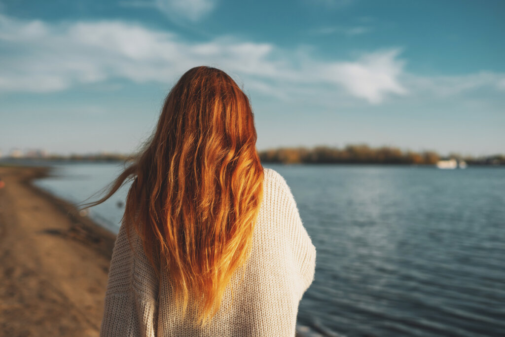 Femme rousse sur le dos réfléchissant à la façon de défaire le nœud des émotions
