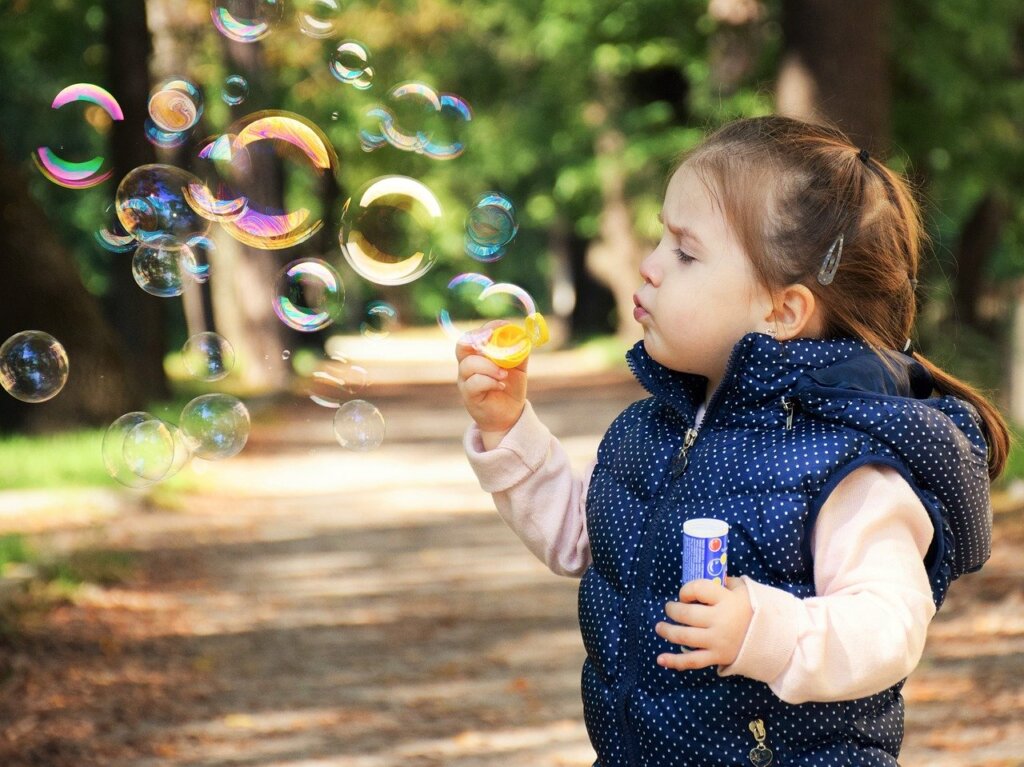 Niña soplando burbujas