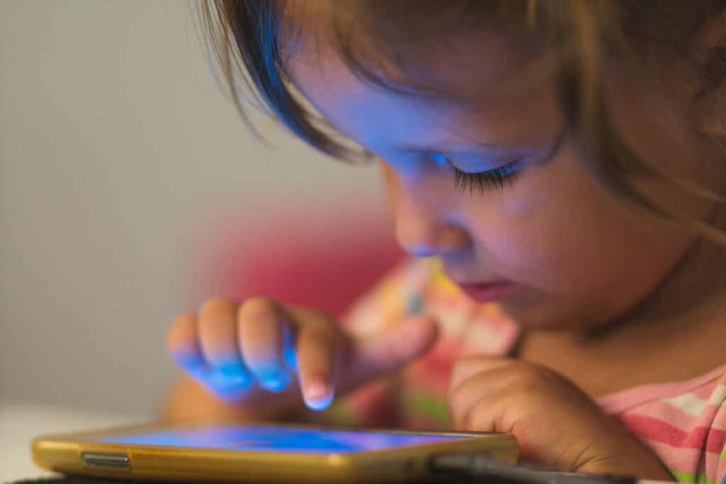 Niña con una tablet representando por qué no deberían ver los niños “El juego del calamar”?