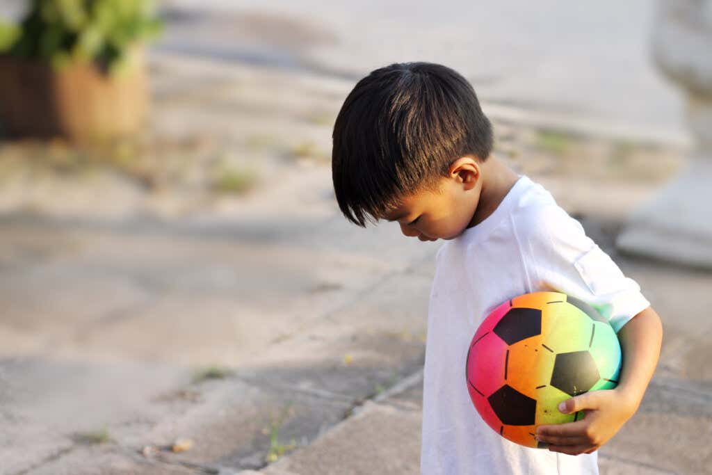 Boy with a ball without friends