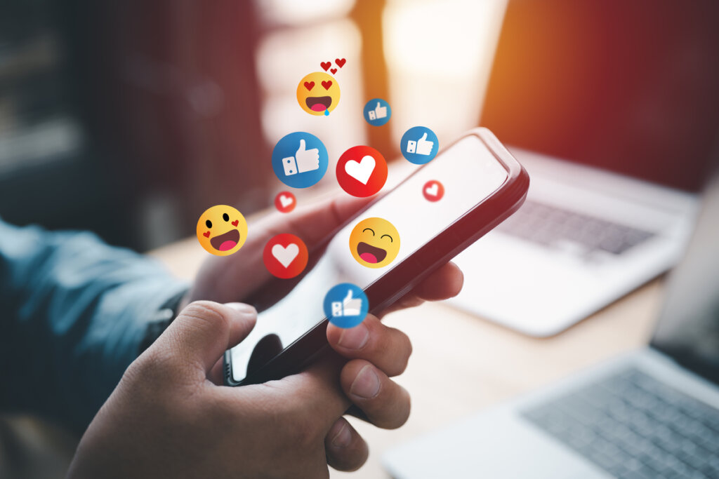 Persona utilizando emoticonos en el móvil