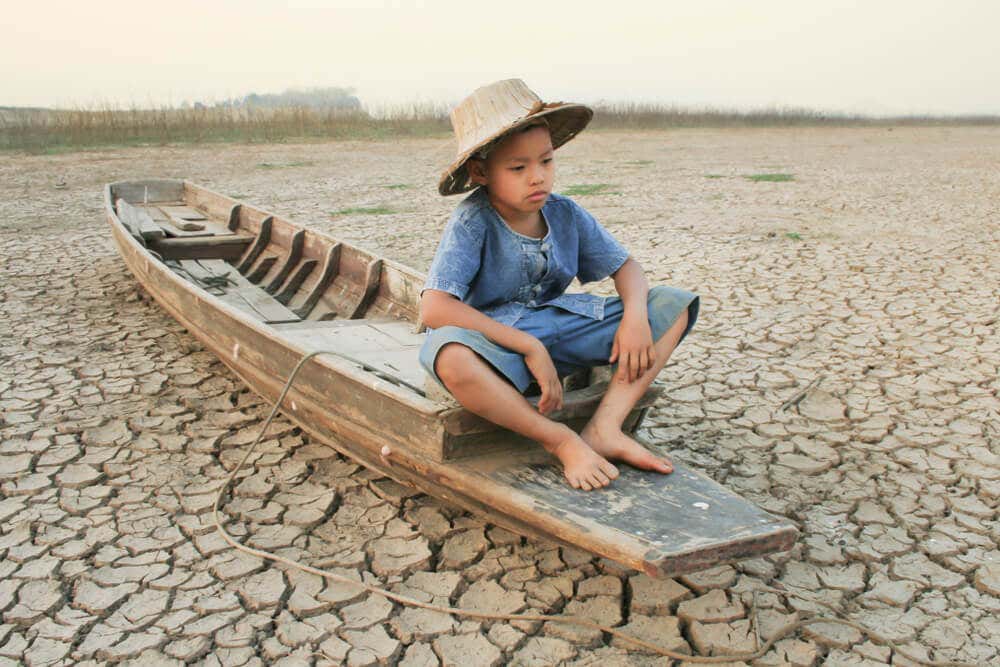 kurak topraklarda tek başına oturan çocuk