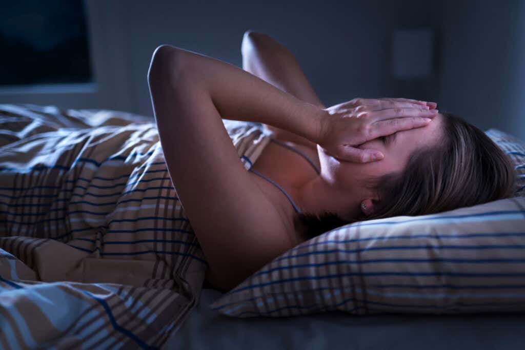 Engstelig kvinne i sengen som symboliserer Når blir angst en lidelse?