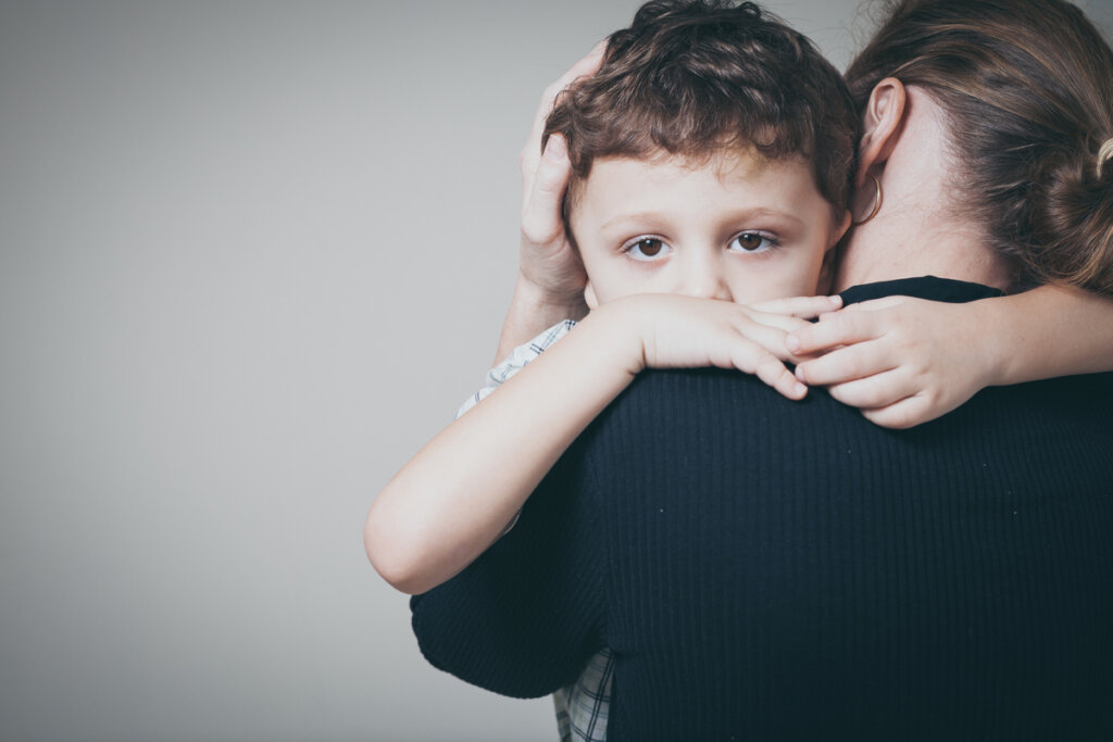 Enfant avec sa mère le serrant dans ses bras