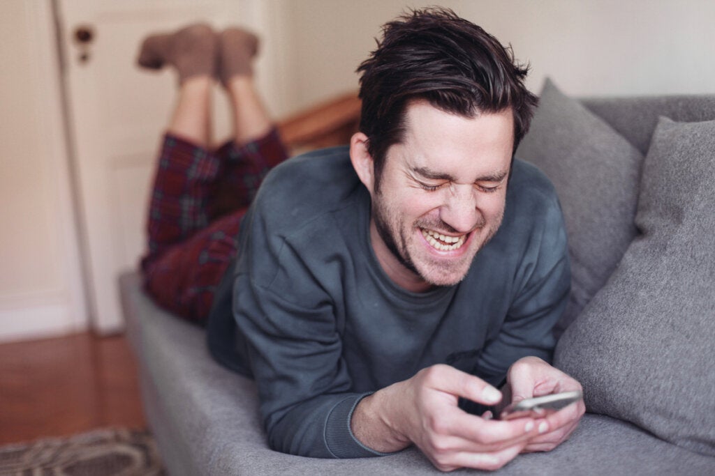 Homem rindo com um celular