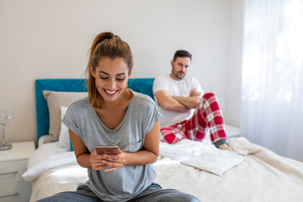 Femme regardant son portable et ignorant son mari