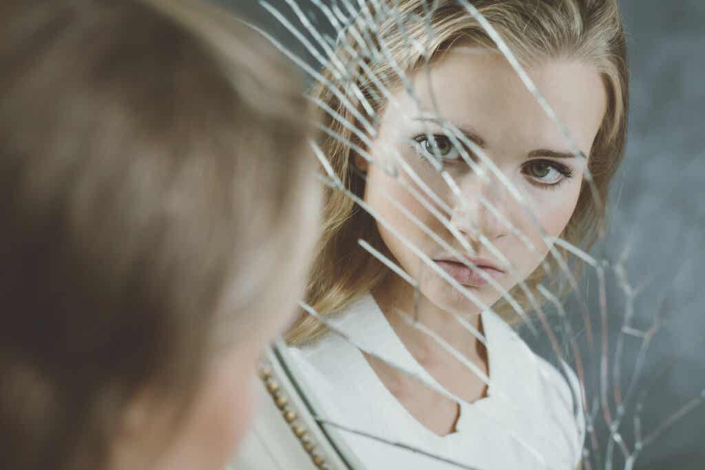 Spiegelbildeffekts - Frau blickt in zerbrochenen Spiegel