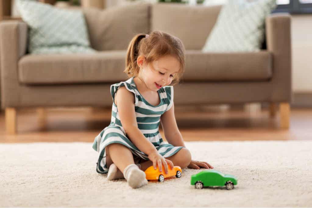 Jente som leker med en lastebil og en bil som representerer barn med større selvkontroll