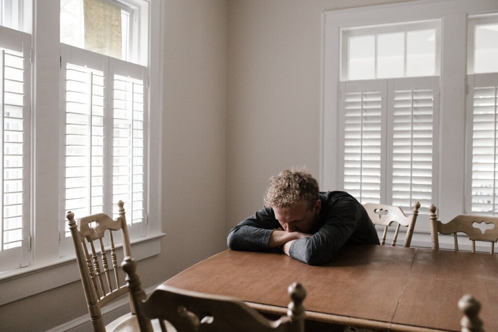 uomo triste seduto nella sala da pranzo che soffre di uno dei sottotipi di depressione maggiore