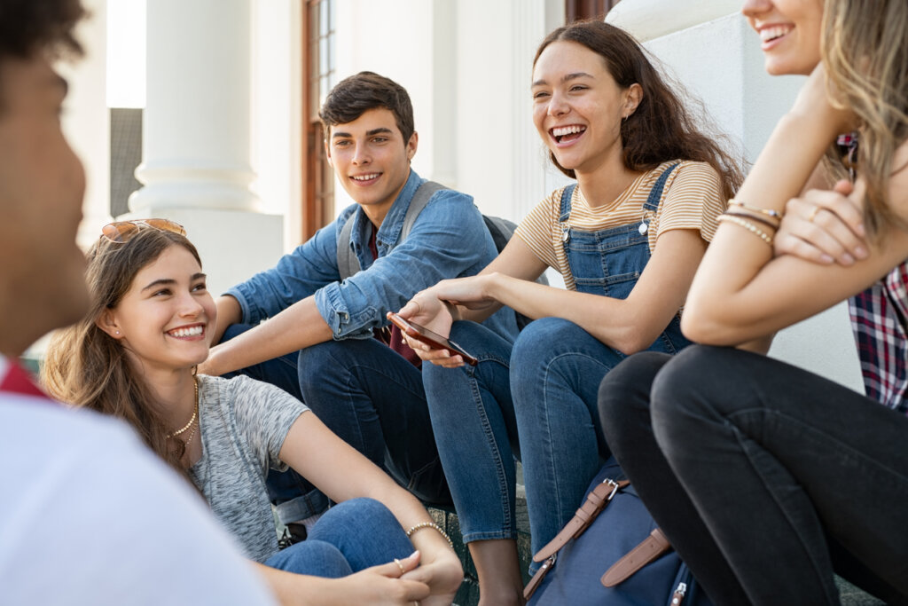 chicos felices hablando sobre cómo las redes sociales afectan más a la salud mental de las niñas