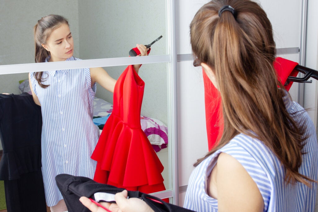 Chica adolescente mirando un vestido rojo