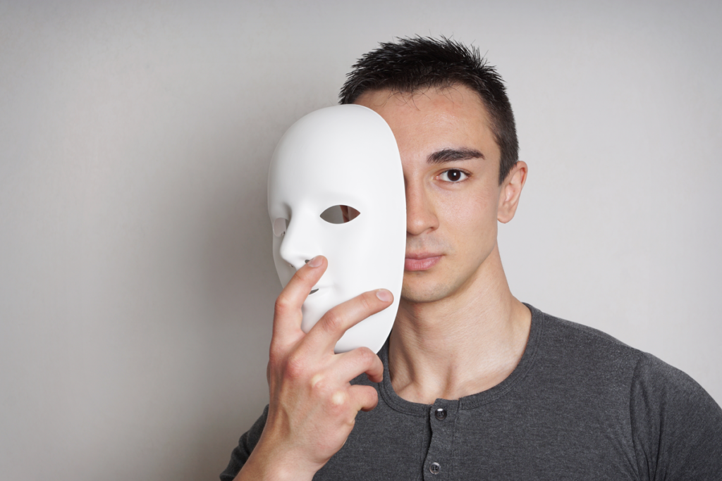 Man bedekt zijn gezicht met een masker