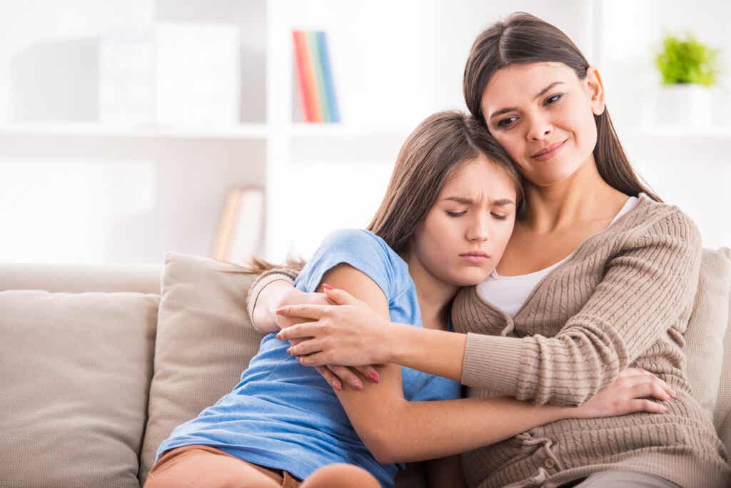 Madre abrazando a su hija preocupada por la primera menstruación