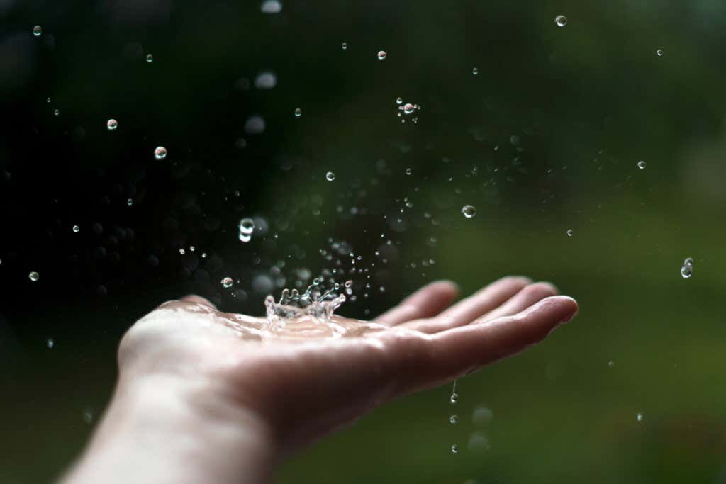 Hand touching the rain