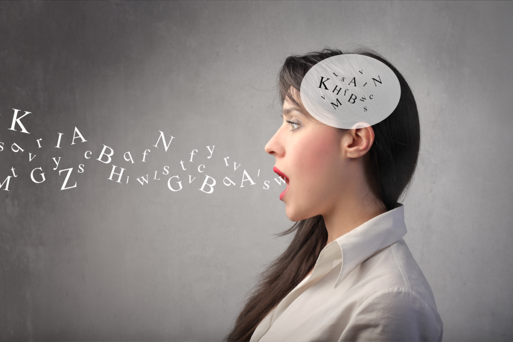 Mujer hablando con letras del alfabeto en la cabeza que salen de su boca simbolizando cómo puede tu voz hacerte parecer más atractivo