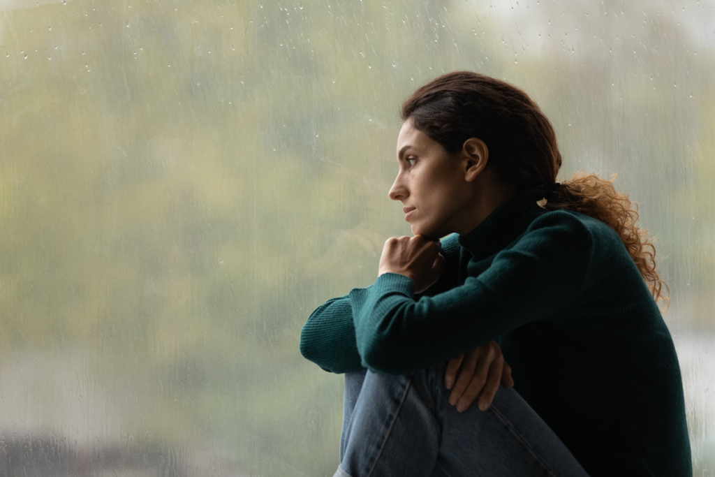 Worried woman looking out of a window